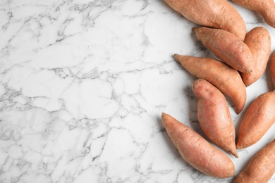 Photo of Flat lay composition with sweet potatoes and space for text on marble background