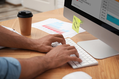 Man using calendar app on computer in office, closeup