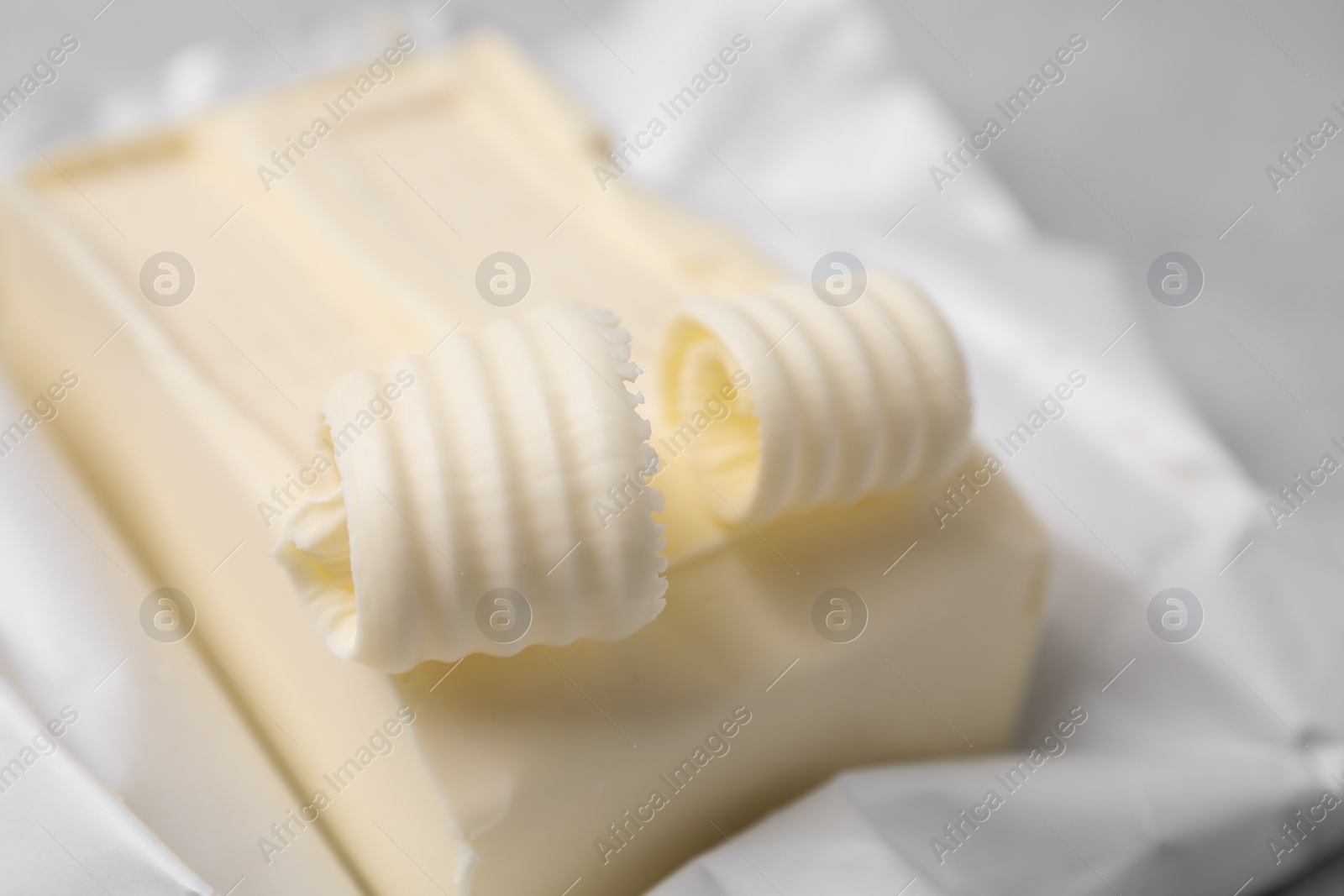 Photo of Tasty butter and curls on table, closeup