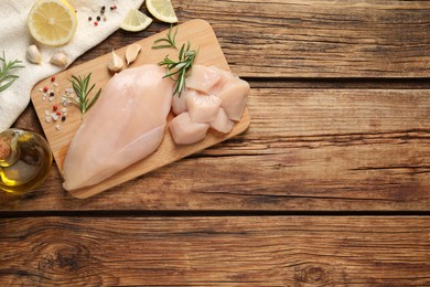 Photo of Flat lay composition with fresh raw chicken breast on wooden table. Space for text