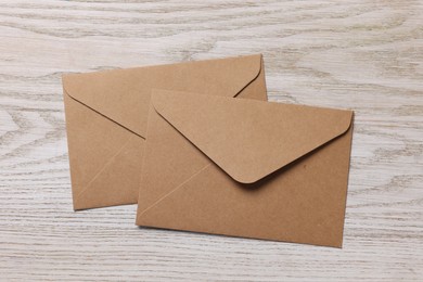 Paper envelopes on white wooden table, flat lay
