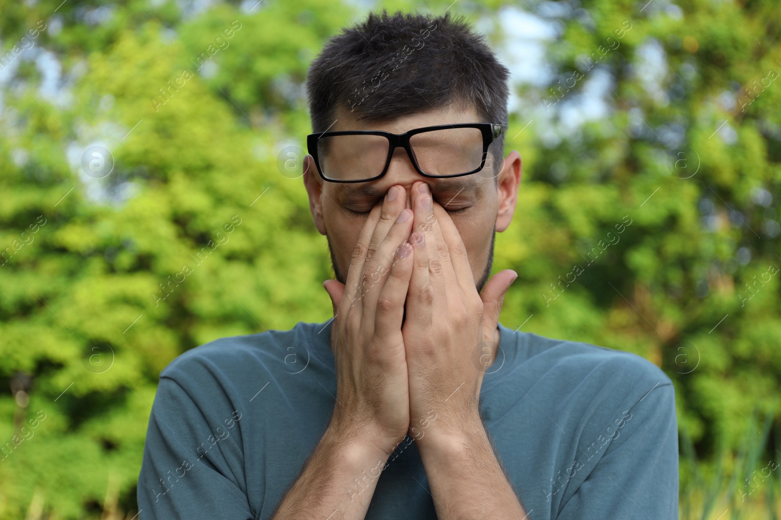 Photo of Man suffering from eyestrain outdoors on sunny day