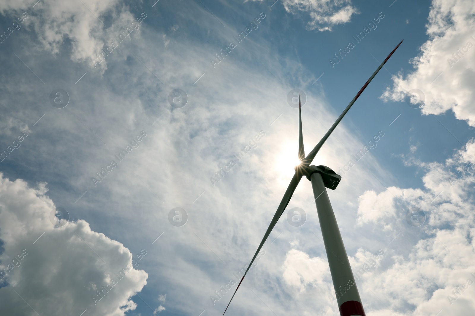 Photo of Modern wind turbine against cloudy sky, low angle view. Alternative energy source