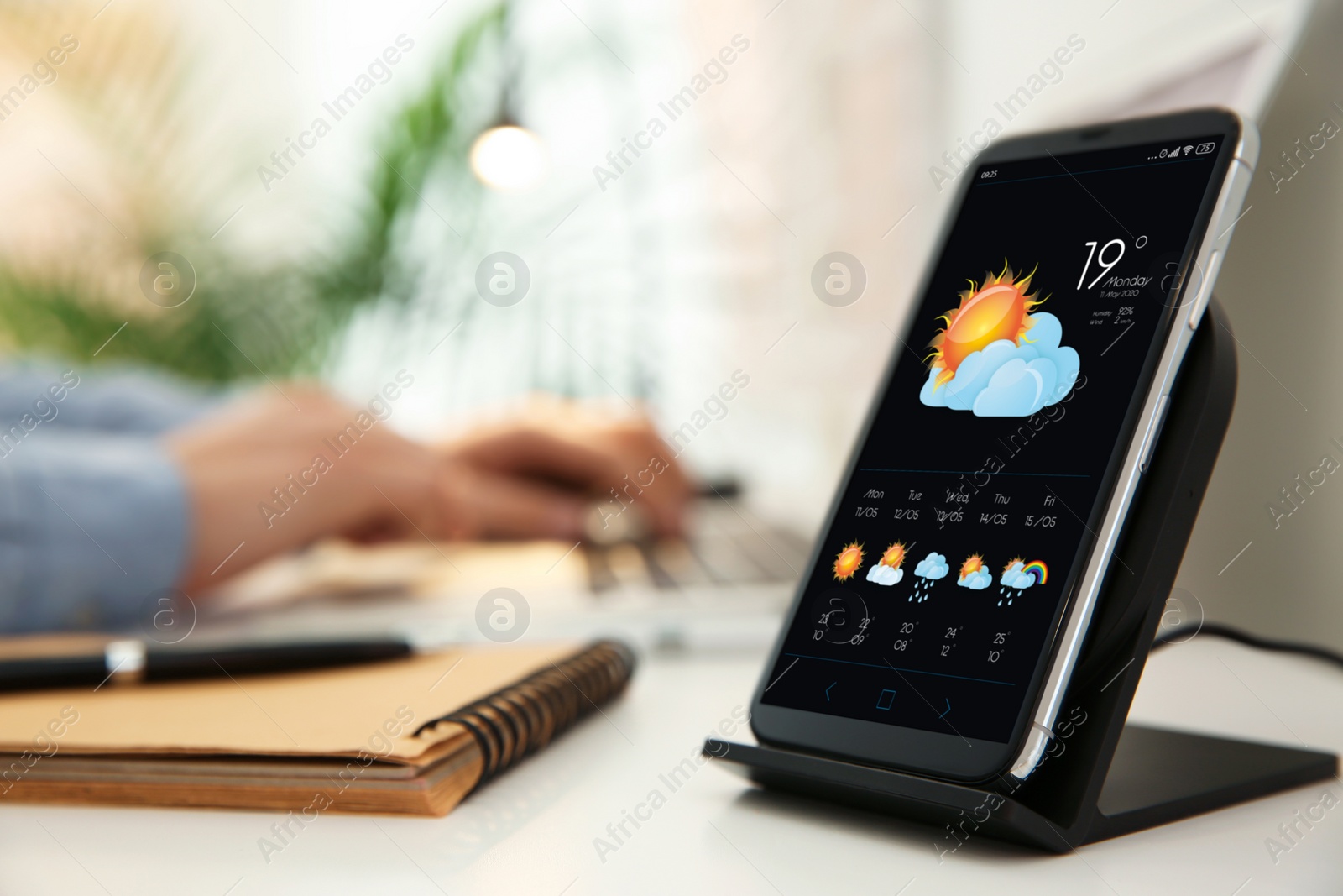 Image of Smartphone with open weather forecast app on white table indoors