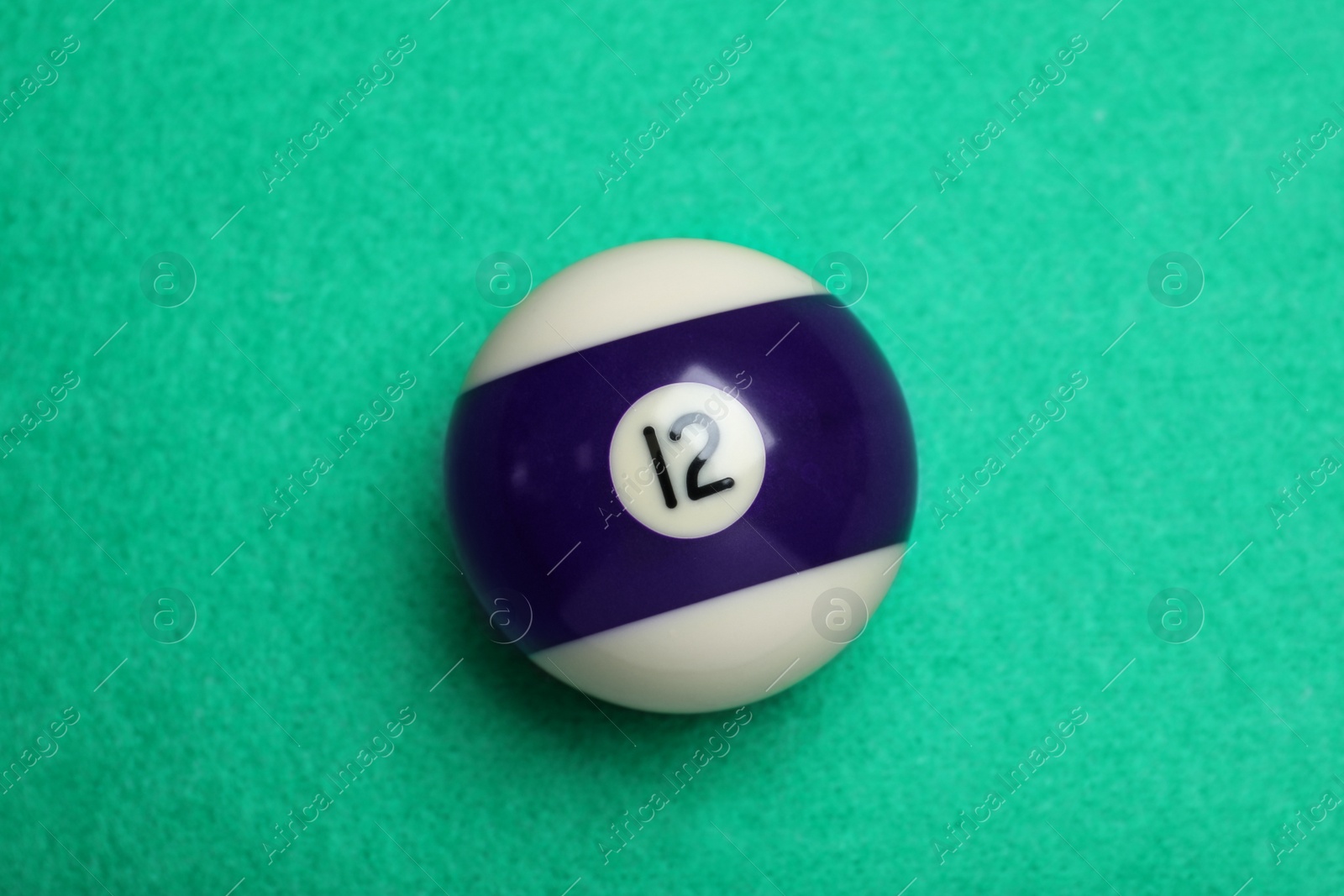 Photo of Billiard ball with number 12 on green table, top view