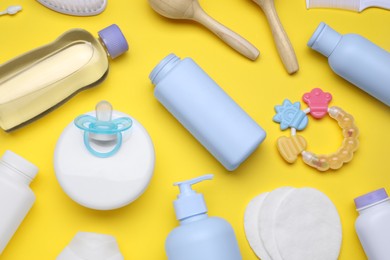 Flat lay composition with baby care products and accessories on yellow background