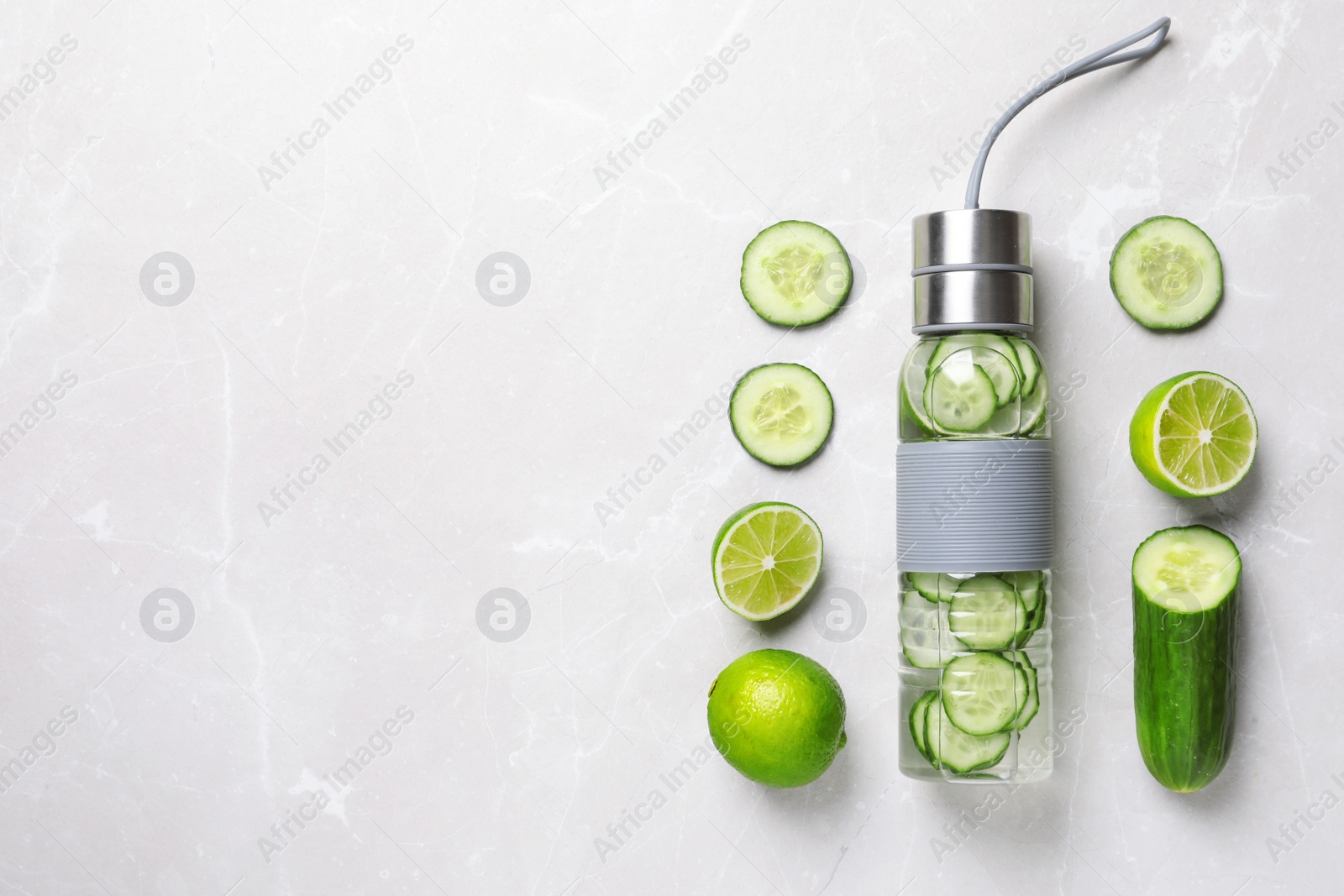 Photo of Flat lay composition with bottle of fresh cucumber water on grey background. Space for text