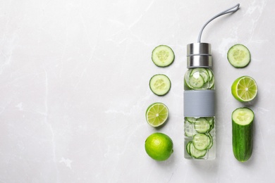 Photo of Flat lay composition with bottle of fresh cucumber water on grey background. Space for text