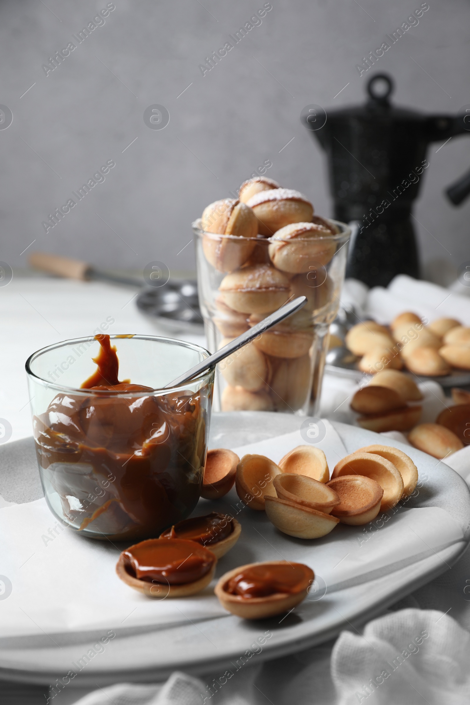 Photo of Delicious walnut shaped cookies with condensed milk on table