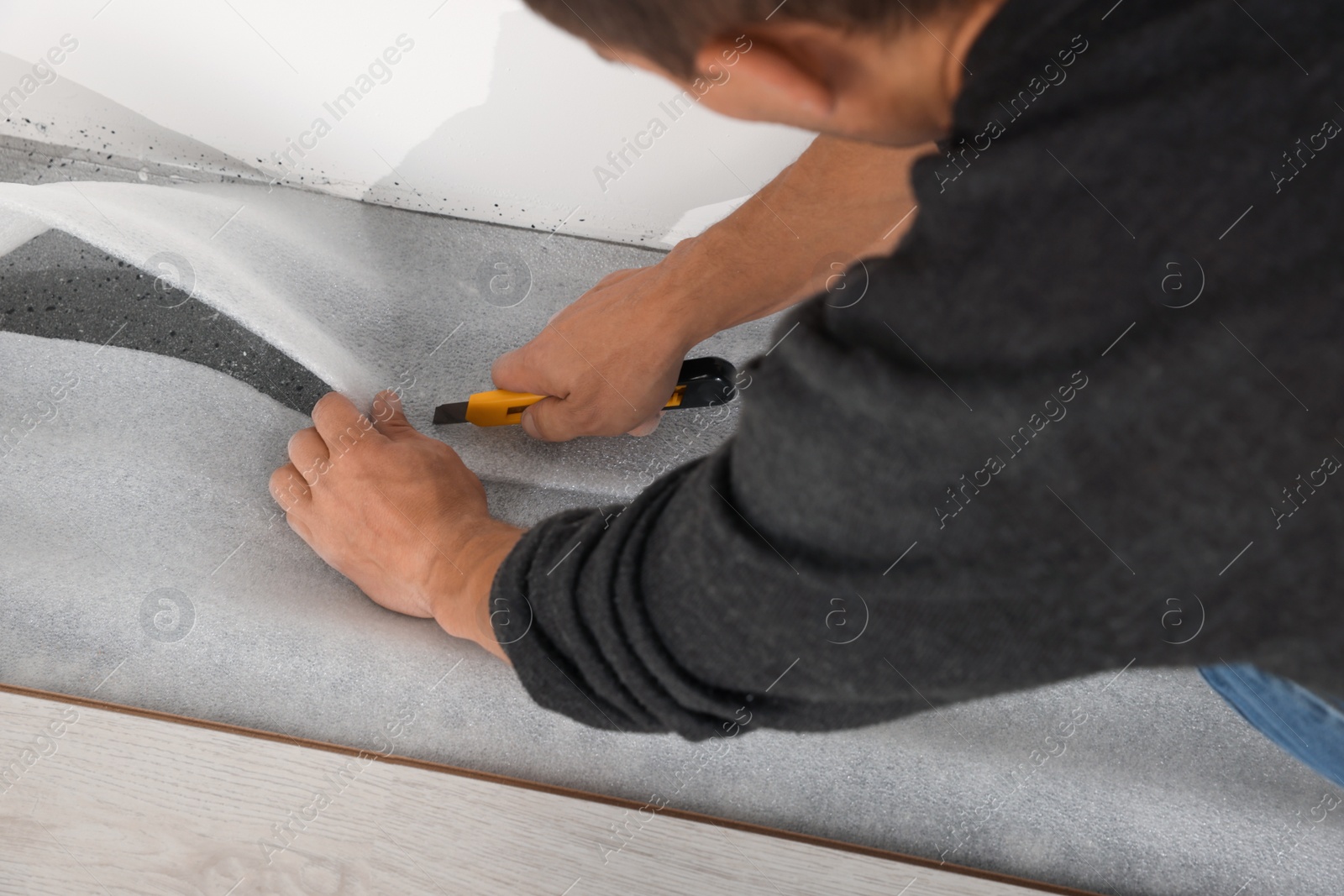 Photo of Worker installing new laminate flooring in room, closeup