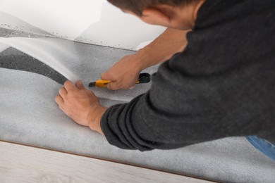 Photo of Worker installing new laminate flooring in room, closeup