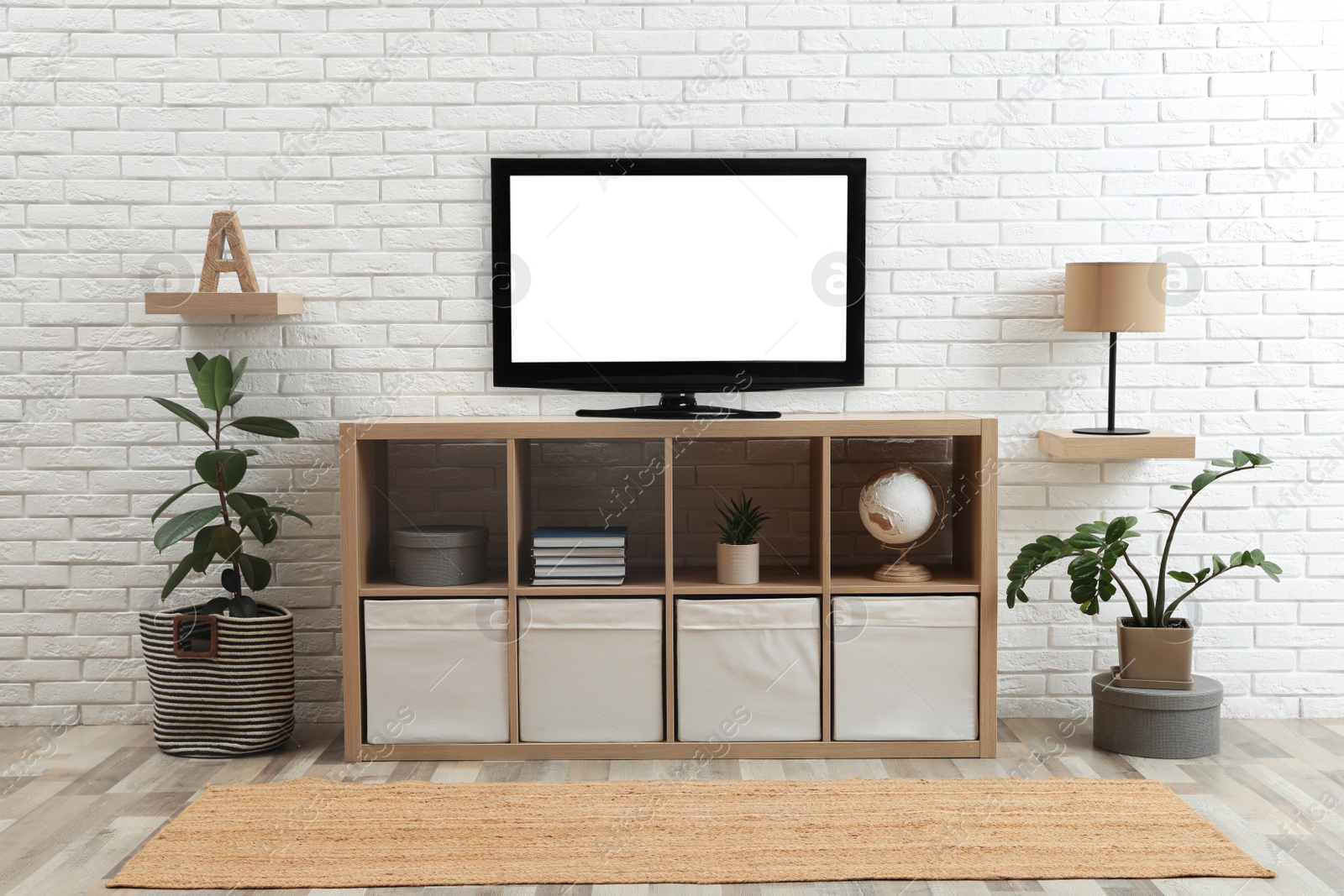 Photo of Modern TV set near white brick wall in living room