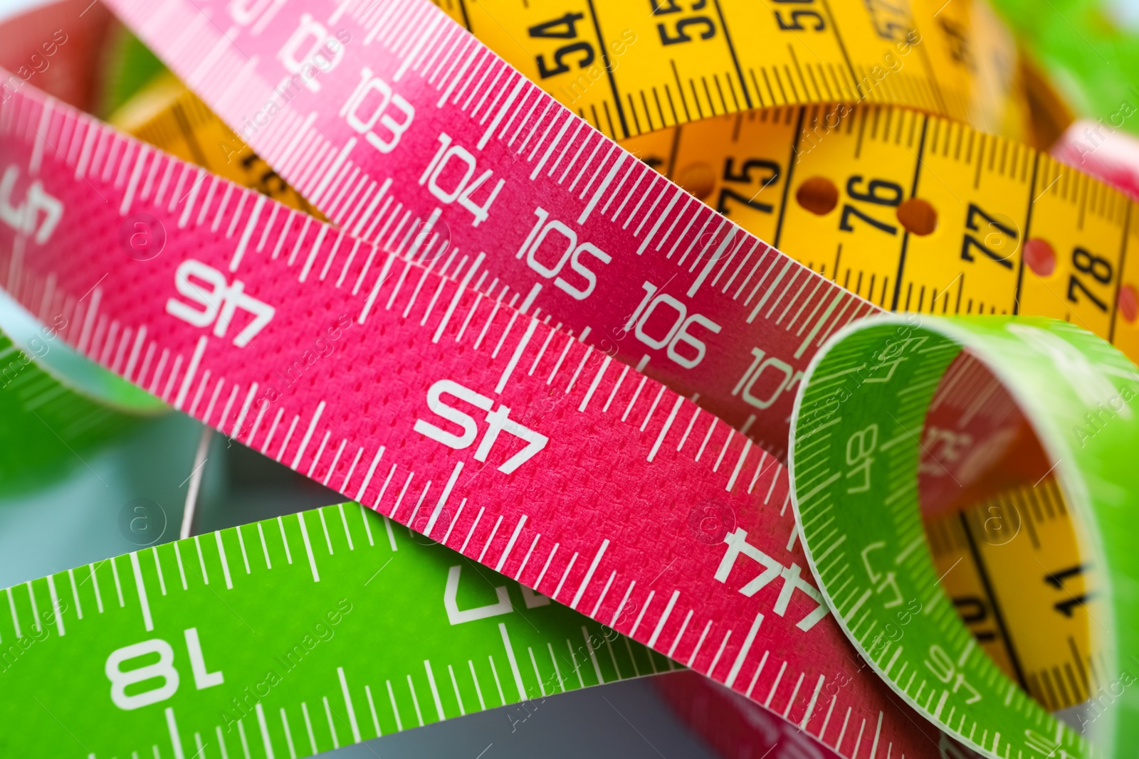 Photo of Kit of different measuring tapes as background, closeup