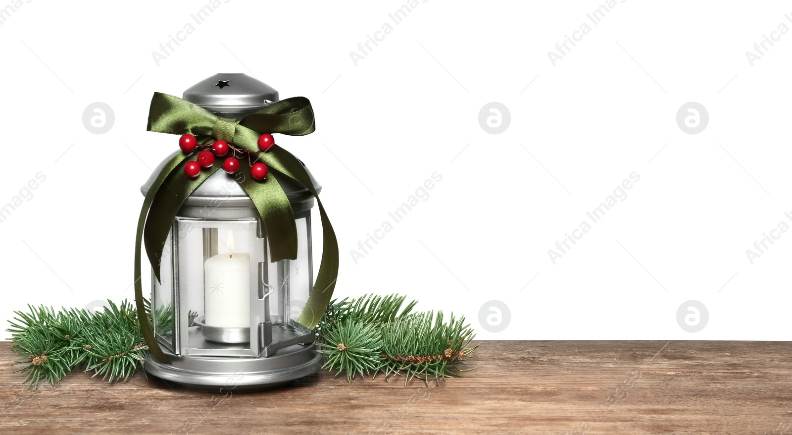 Photo of Christmas lantern with burning candle and fir branch on wooden table, space for text