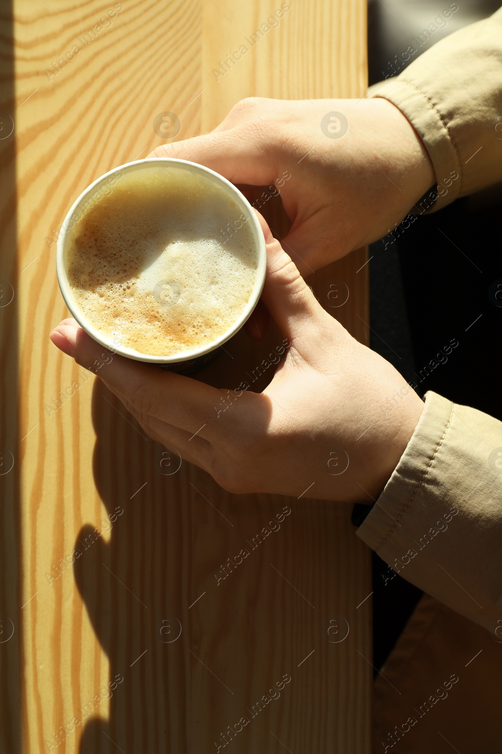 Photo of Woman with cup of fresh aromatic coffee at table in cafe