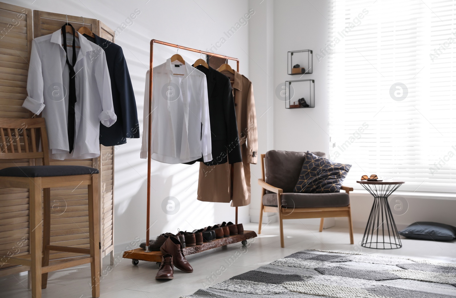 Photo of Dressing room interior with clothing rack and armchair