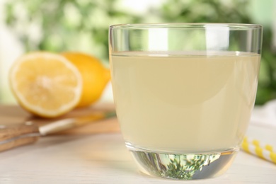 Delicious refreshing drink on white wooden table, closeup