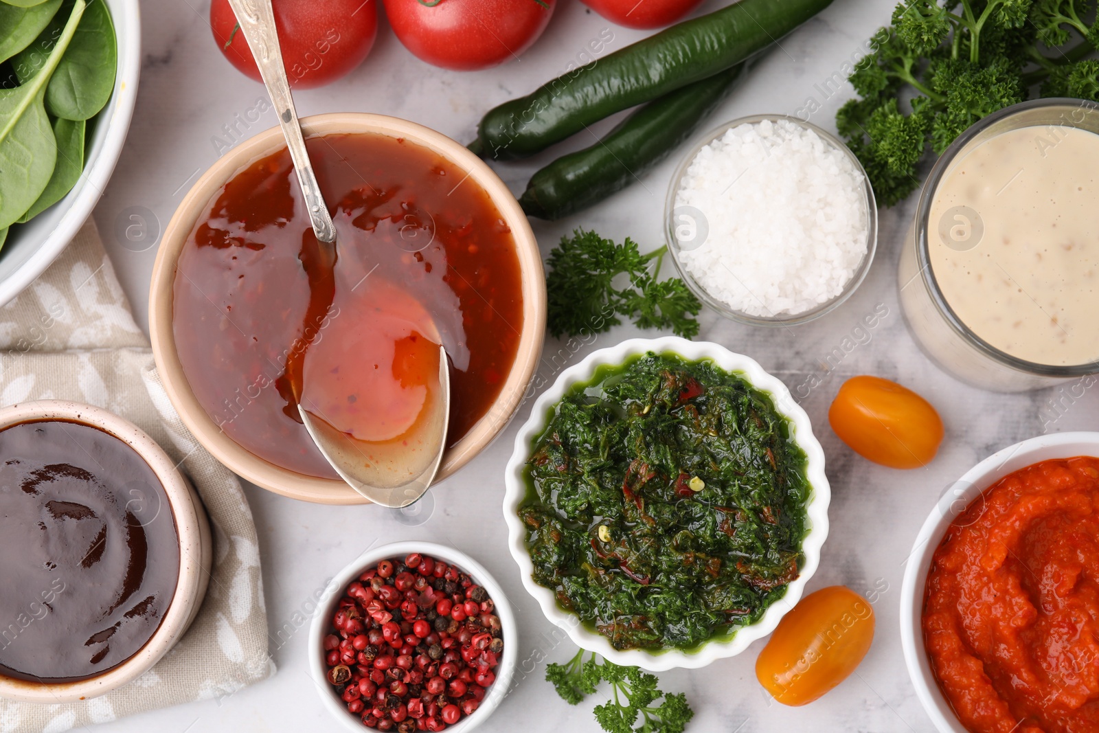 Photo of Different marinades and products on white marble table, flat lay