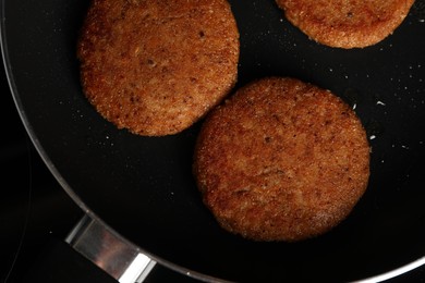 Cooking vegan cutlets in frying pan, top view