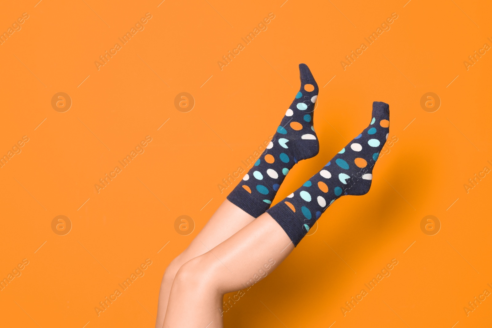 Photo of Woman wearing bright socks on color background