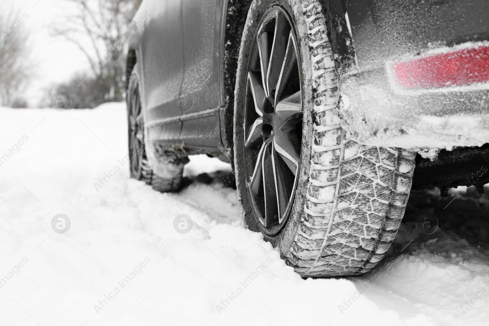 Photo of Snowy country road with car on winter day, closeup