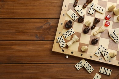 Photo of Elements of different board games on wooden table, flat lay. Space for text
