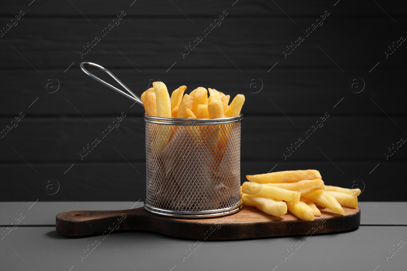 Photo of Tasty French fries on grey wooden table