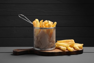 Tasty French fries on grey wooden table