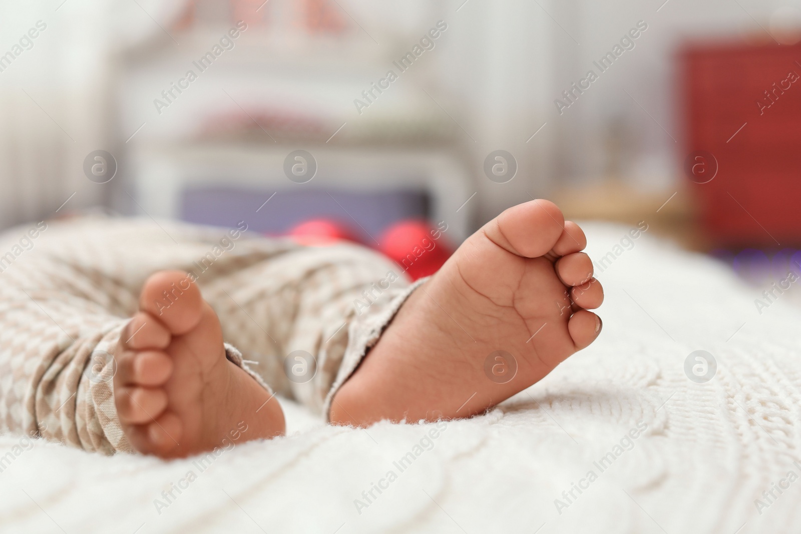 Photo of Closeup of little African-American baby's legs. First Christmas