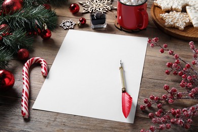 Photo of Blank paper sheet and Christmas decor on wooden table, space for text. Letter for Santa