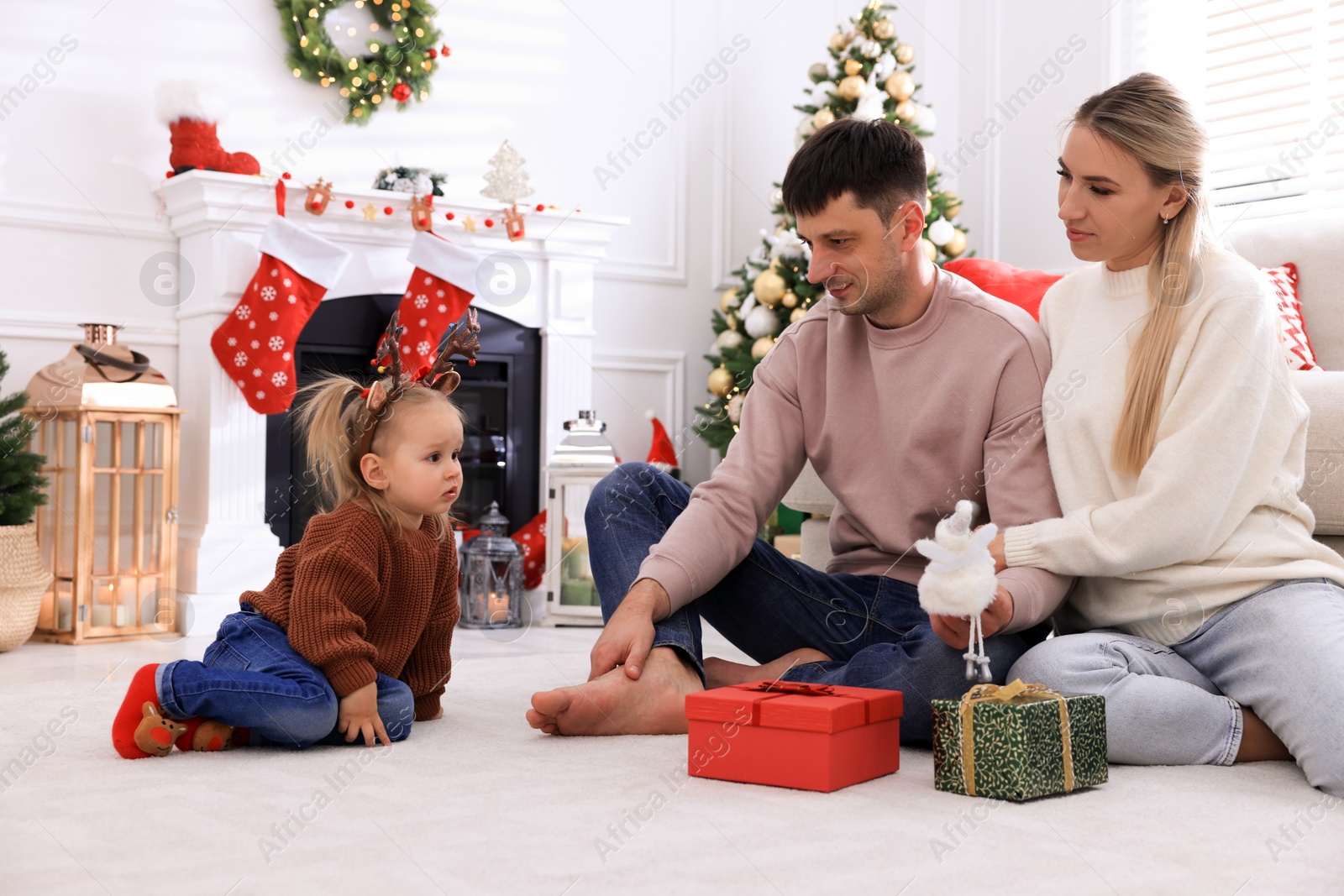 Photo of Happy family with gifts in room decorated for Christmas