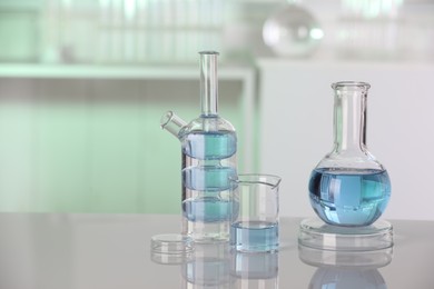 Laboratory analysis. Different glassware with liquid on white table indoors. Space for text