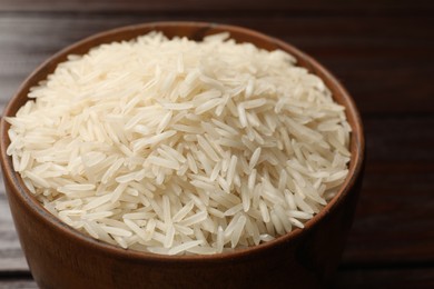 Photo of Raw basmati rice in bowl on table, closeup