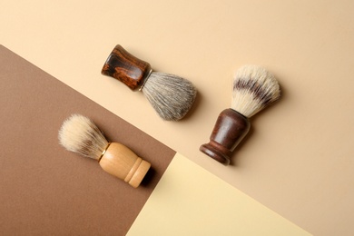 Flat lay composition with shaving brushes for men on color background