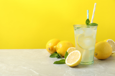 Photo of Natural freshly made lemonade on light grey marble table, space for text. Summer refreshing drink