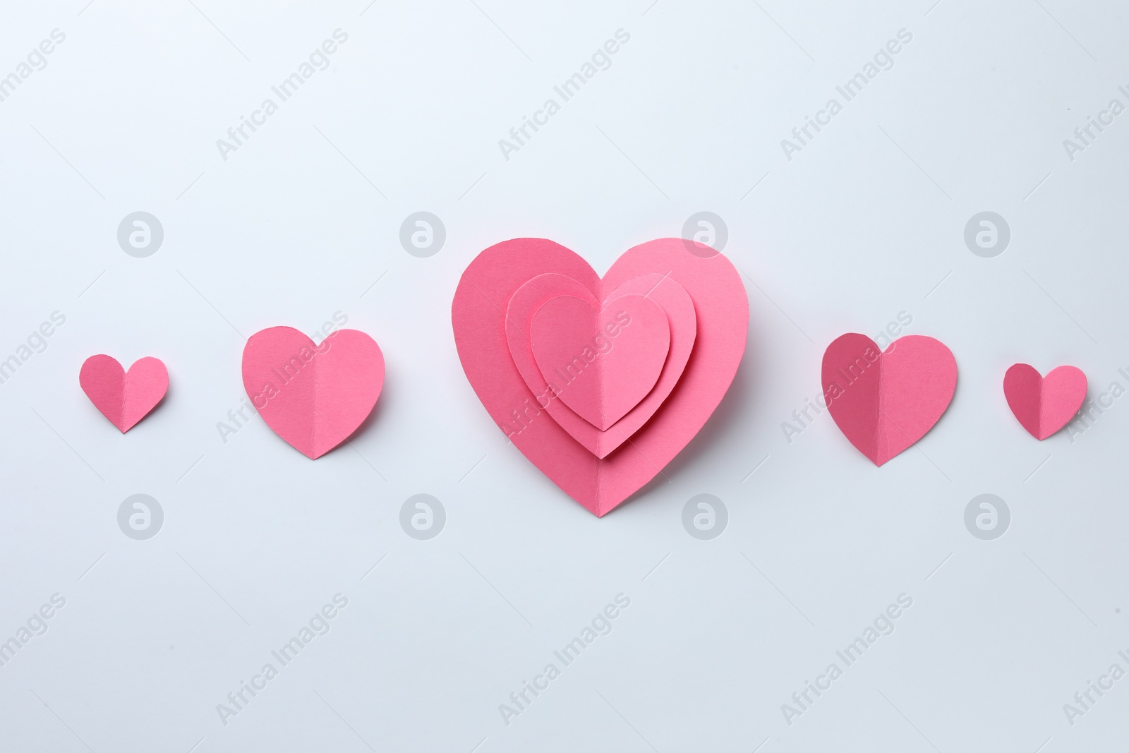 Photo of Pink paper hearts on white background, flat lay