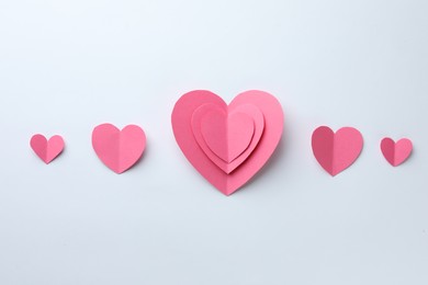 Pink paper hearts on white background, flat lay