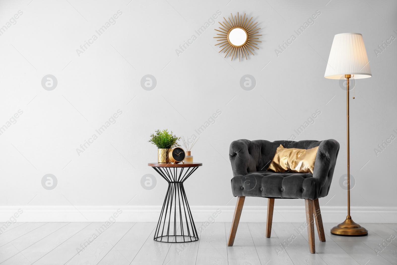 Photo of Stylish room interior with comfortable armchair, floor lamp near light wall, space for text