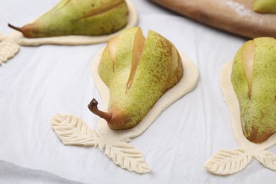 Raw dough with fresh pears on table, closeup