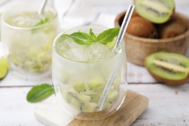 Photo of Refreshing drink with kiwi and mint on white table, closeup