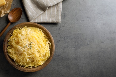 Photo of Flat lay composition with plate of cooked spaghetti squash and space for text on gray background