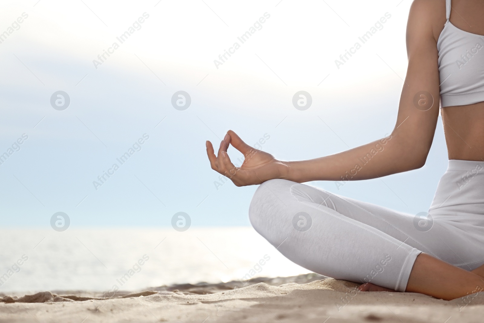 Photo of Young woman practicing zen meditation on beach, closeup. Space for text