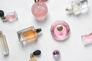 Photo of Different luxury perfume bottles on white background, top view