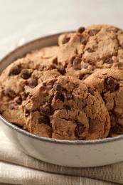 Photo of Delicious chocolate chip cookies in bowl on table, closeup