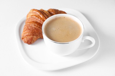 Photo of Fresh croissant and coffee on white background. Tasty breakfast