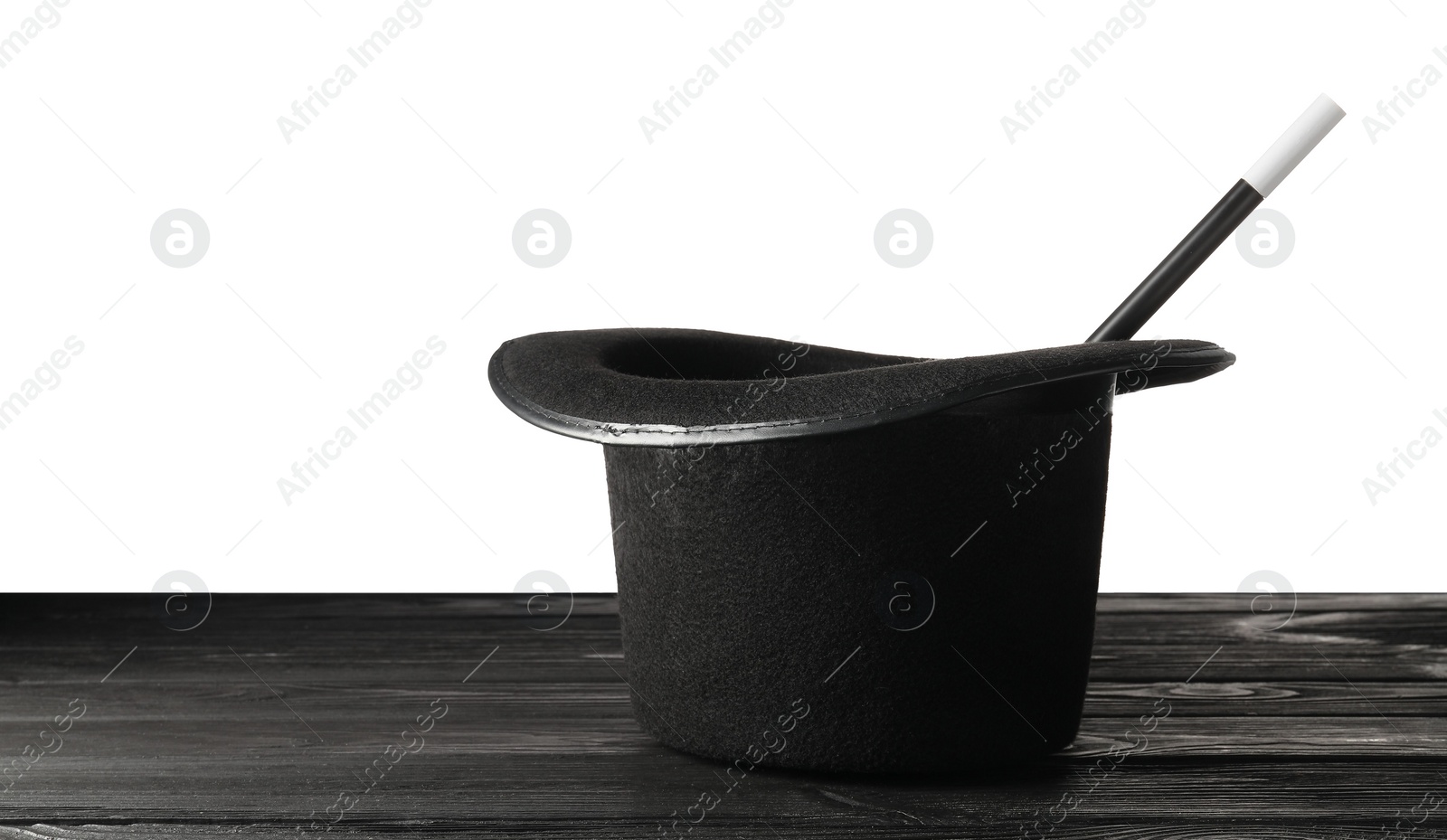 Photo of Magician's hat and wand on wooden table against white background