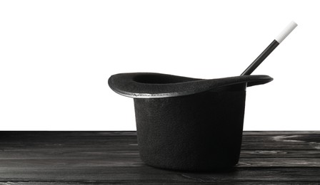 Photo of Magician's hat and wand on wooden table against white background