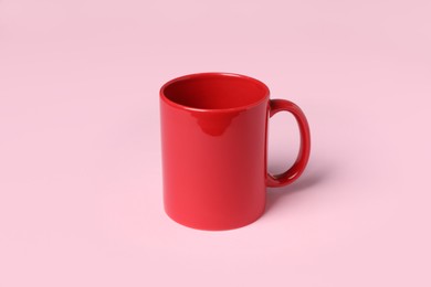 Photo of One red ceramic mug on pink background