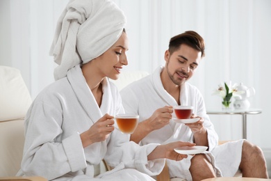 Photo of Romantic young couple with tea in spa salon