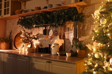 Photo of Stylish kitchen with festive decor and Christmas tree. Interior design